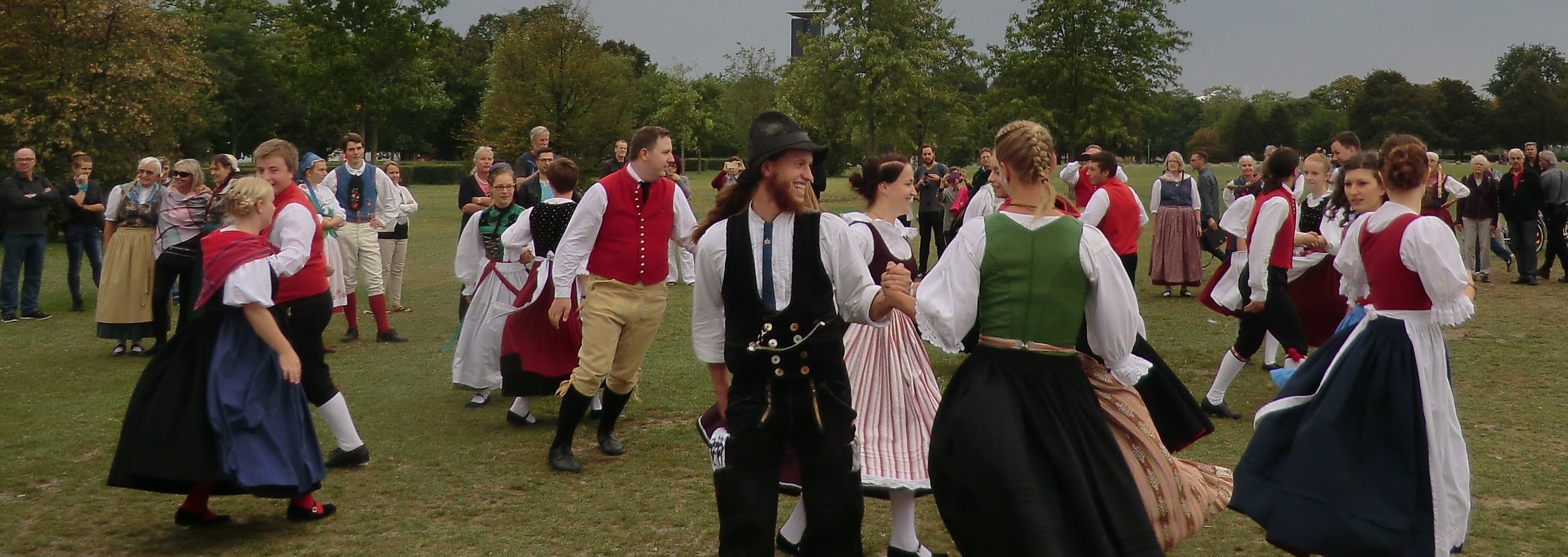 Jugendliche tanzen in Tracht im Freien